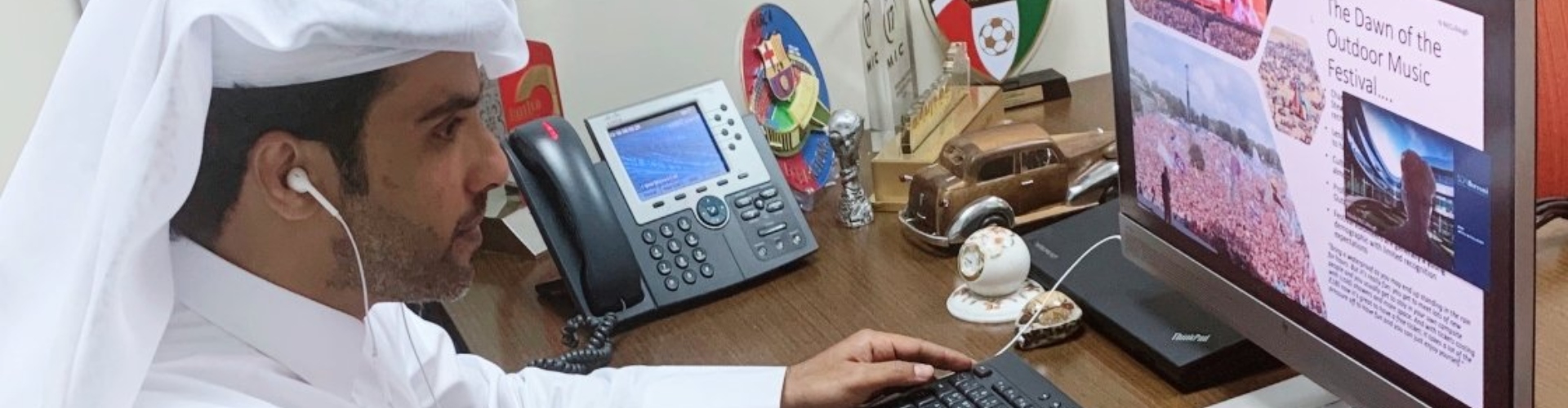 A man in traditional clothing uses computer as he attends a Josoor online class.