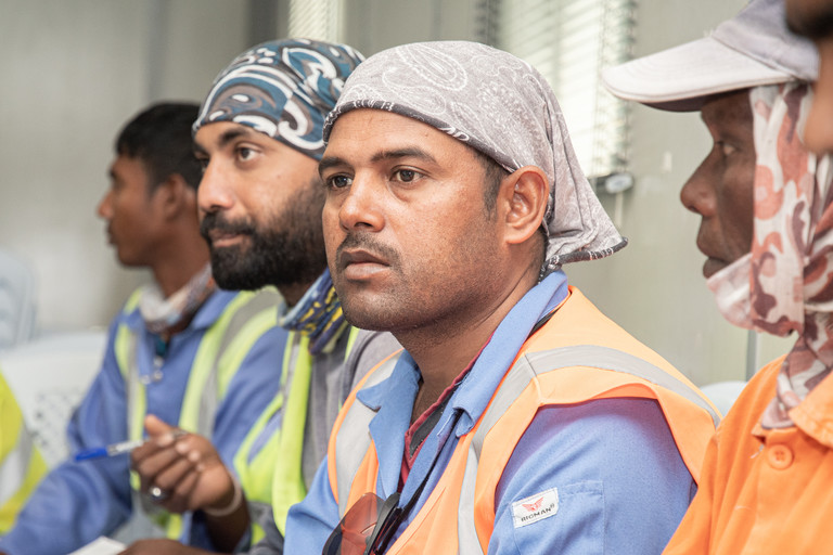 عمال يجلسون في مكان سكنهم – أحد مواقع البناء التابعة لكأس العالم FIFA قطر ٢٠٢٢™